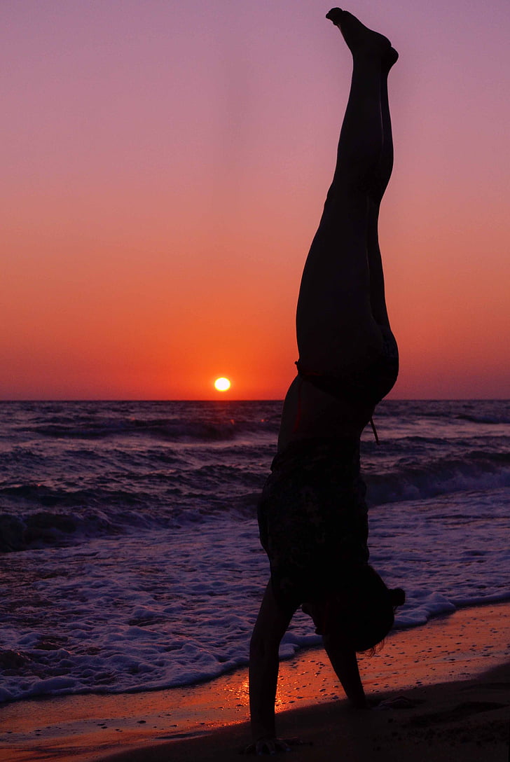 silhouette of man beside seashore during sunset