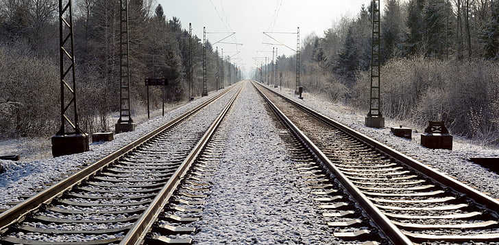 empty train railroad near trees at daytime