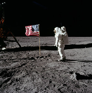 astronaut on moon in front of American flag photo