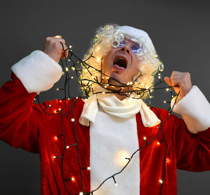 man in white Santa Claus costume choking himself using string lights