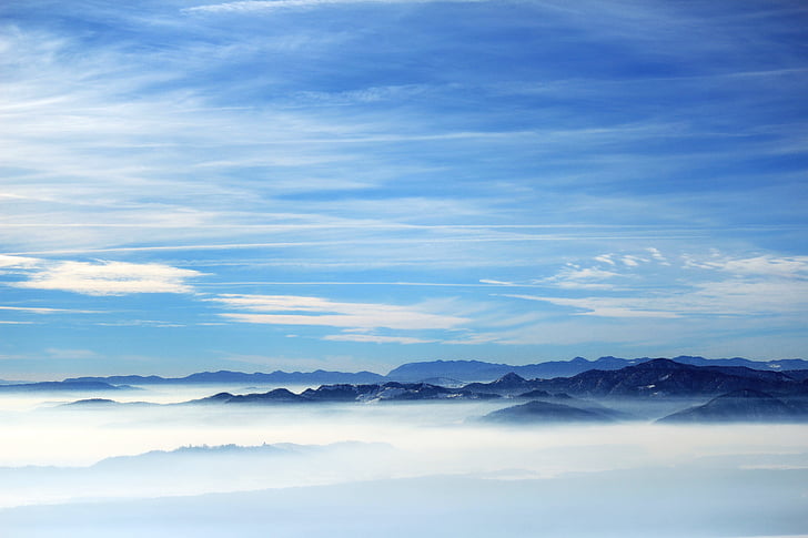 mountain range above clouds during daytime