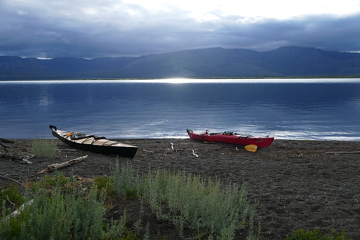 two red and black canoes on seashore