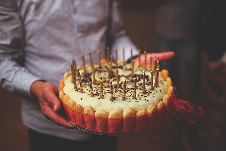 man holding cake with candles