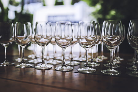 selective focus photography of clear wine glass lot on top of brown wooden table