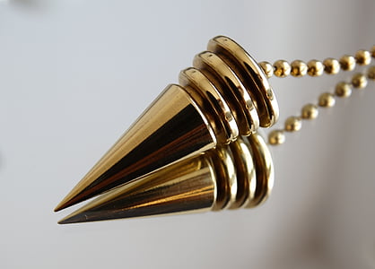 macro shot photography of gold-colored pendant