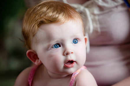 blue-eyed baby wearing pink spaghetti strap top