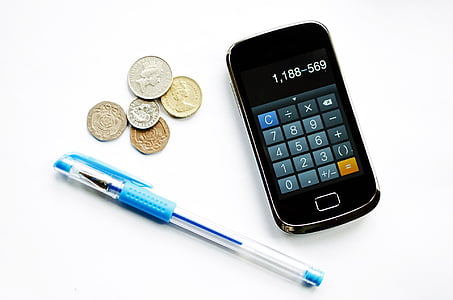 blue pen beside coins and black slide phone