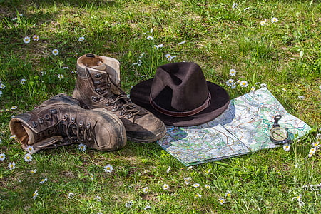 brown fedora hat and brown boots near map