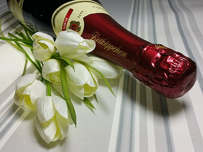 white flowers beside wine bottle