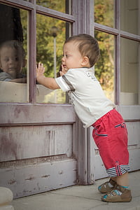 child facing smoke-glass window