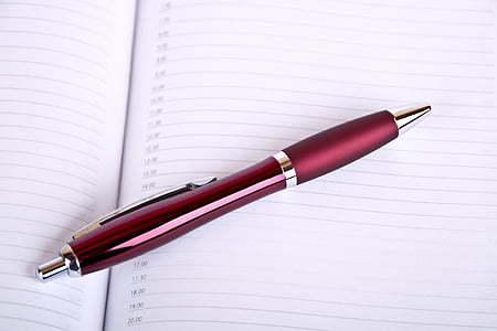 red retractable pen on ruled paper