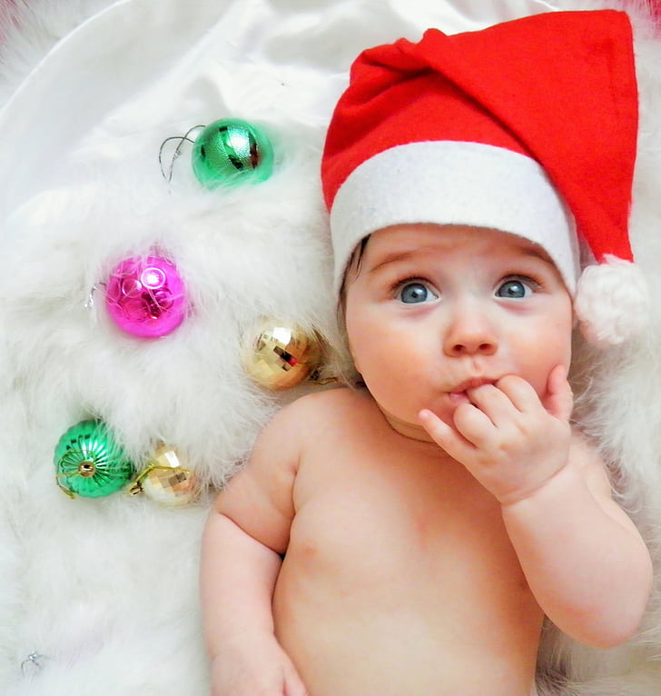 closeup photo of baby wearing Santa hat