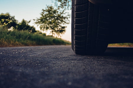 low-angle photography of vehicle tire on the middle of the road