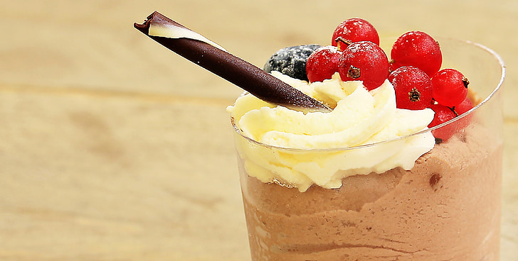 glass of chocolate shake with cherries and wafer stick