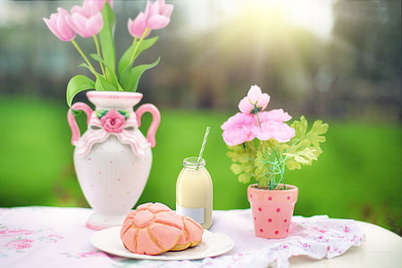 pink petaled flower centerpiece on table beside bread