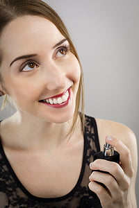 woman wearing black sleeveless top holding black spray bottle