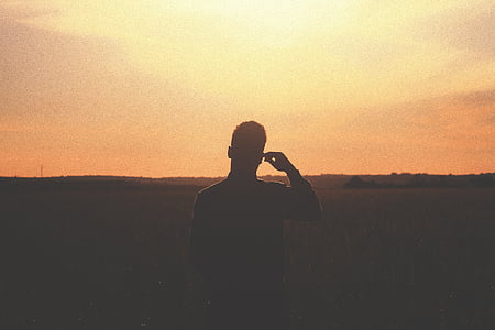 silhouette photography of person under yellow sky