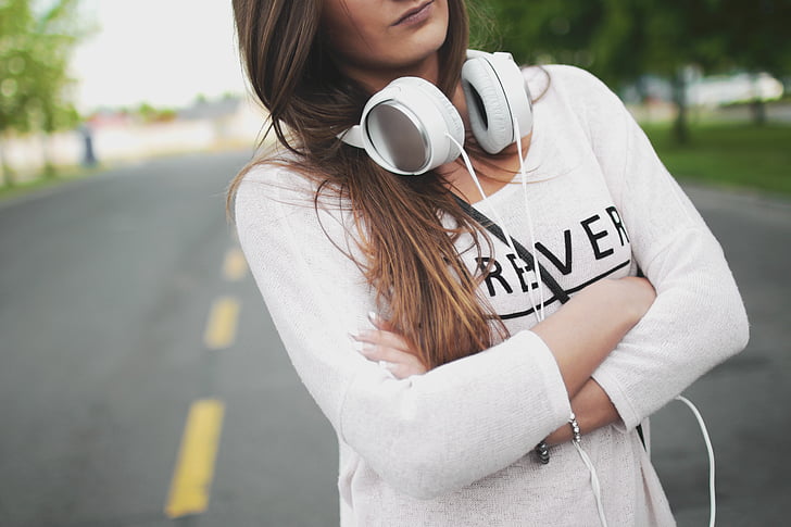woman wearing white long-sleeved top with headphones