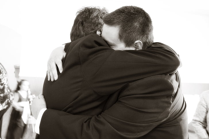 men wearing suit hugging
