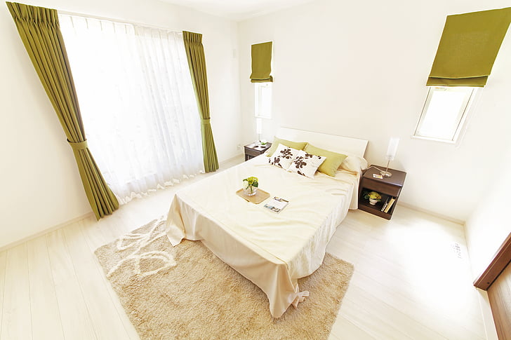 bed with headboard and beige comforter in room