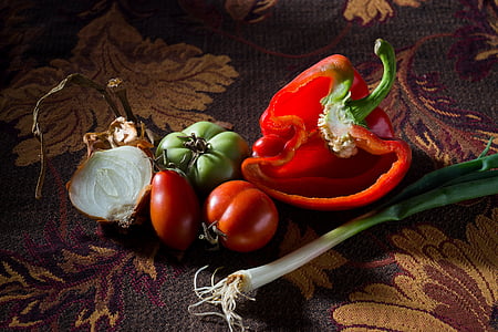 slice red bell pepper, onions and red tomato fruit on brown floral textile