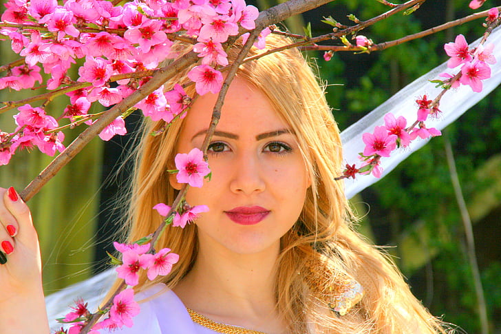 woman holding cherry blossom tree branch