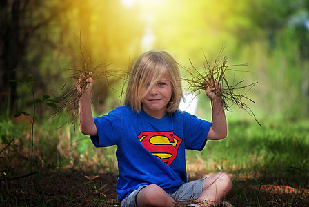 shallow focus photography of boy in blue Superman shirt