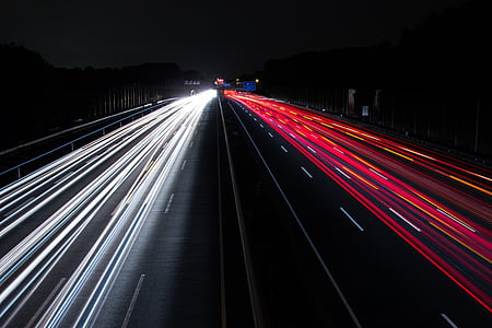 time lapse photography of vehicle passing on road during nighttime