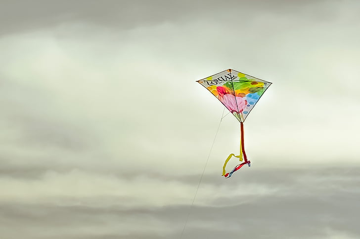 multicolored kite under gray cloudy sky