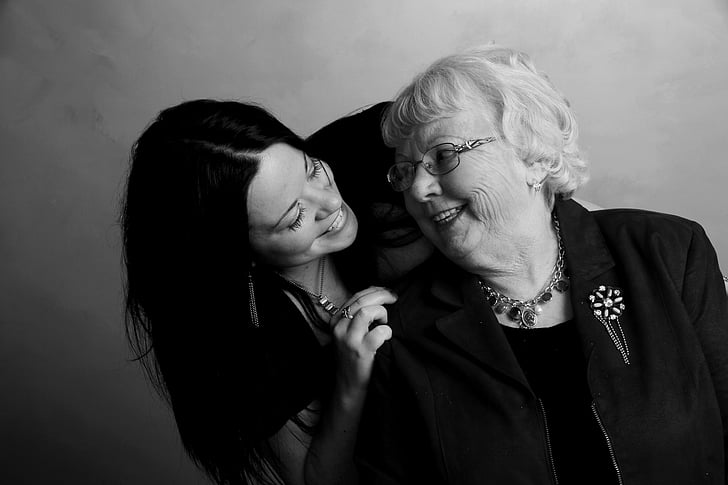 black haired woman holding white haired woman