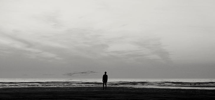 silhouette of person standing person near water