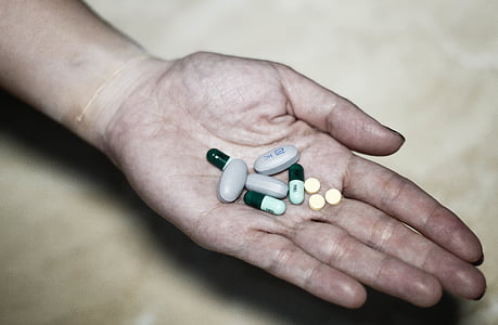 person holding medication pills