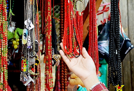 person holding beaded necklaces