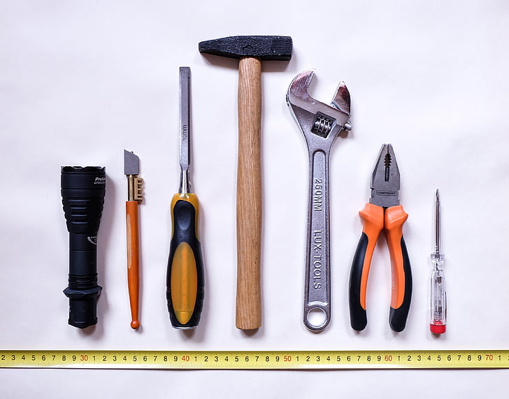 seven assorted-color handheld tools on white background