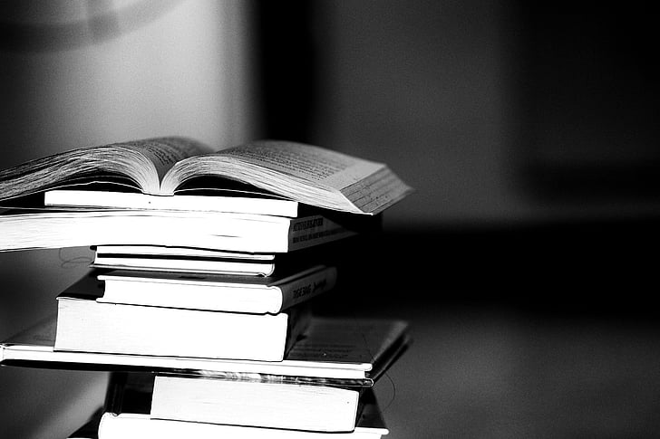 pile of books grayscale photography