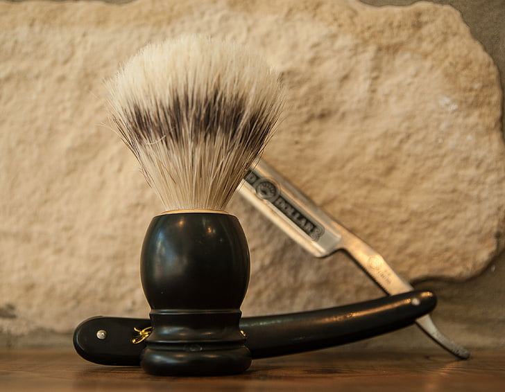 black and white shaving brush and black handled gray straight razor