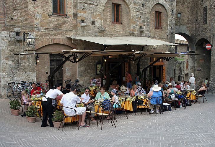 group of people dining outside brown concrete building