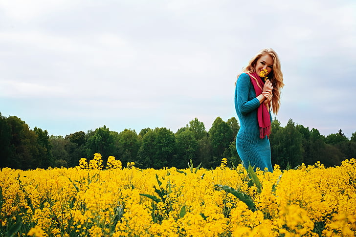 woman in blue dress on field of yellow flower