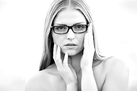 woman touching her face while wearing eyeglasses