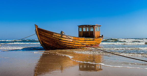 brown boat on seashore during daytime