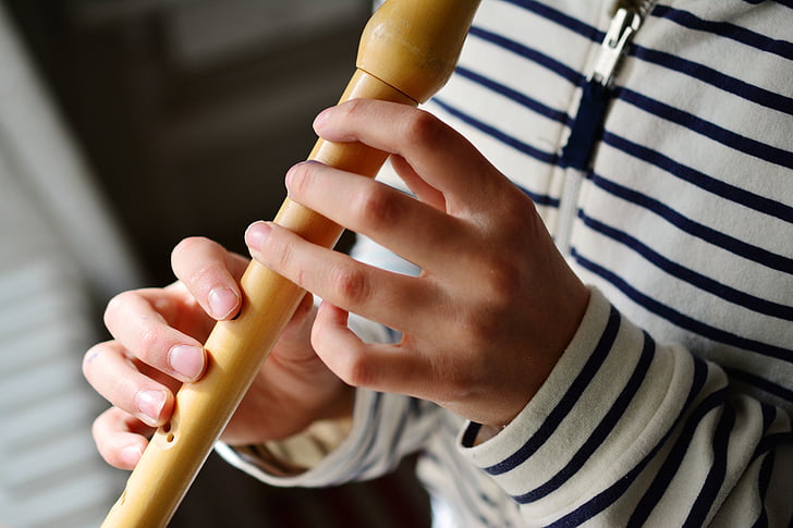 person playing wooden flute