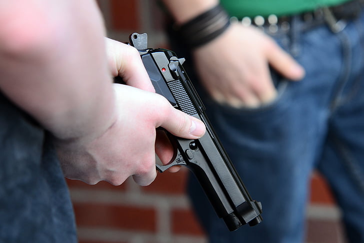 person holding black semi-automatic pistol