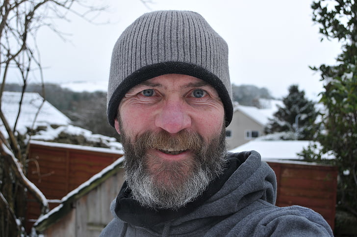 smiling man wearing gray knit hat outdoor