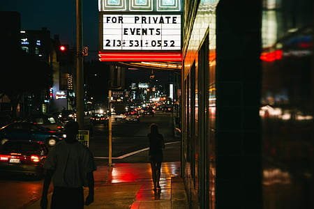 photo of person standing near signage during nighttime