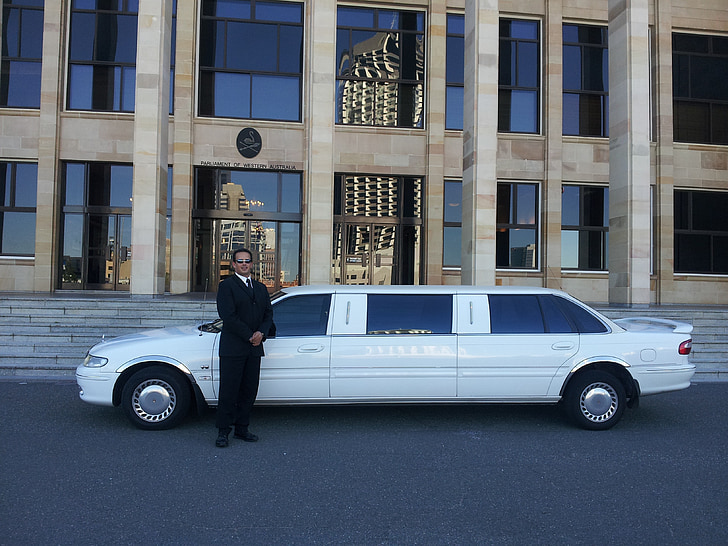 man standing beside white limousine