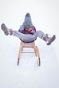 woman riding sled lifting both feet