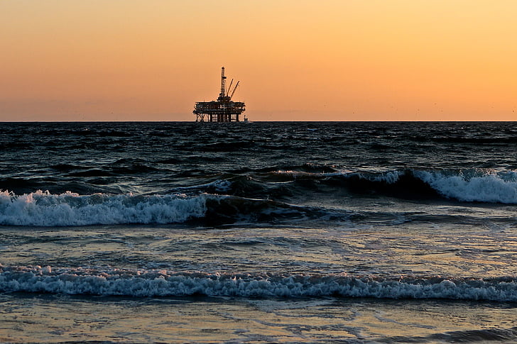 oil rig on the sea photo during sunset