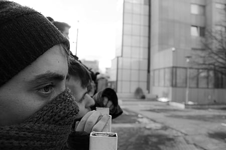 grayscale photography of people near steel barricade
