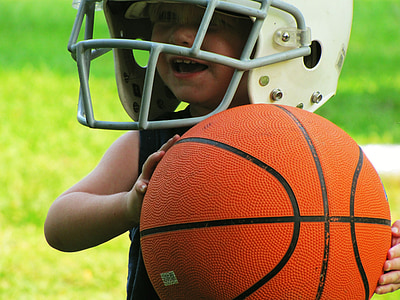 closeup photo of wearing NFL helmet holding a basketball