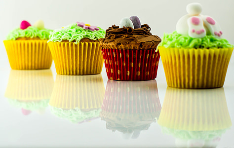 closeup photo of four cupcake on white surface